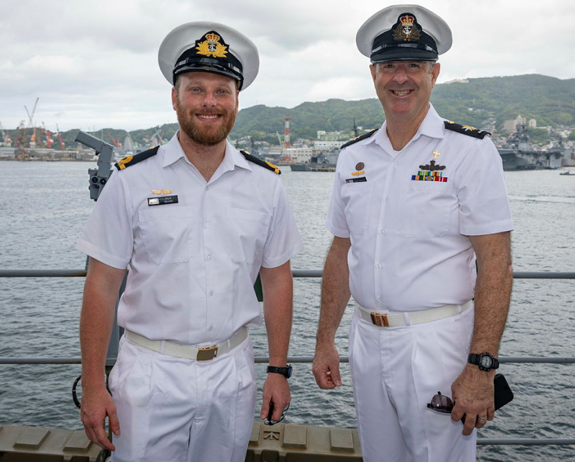 Chaplain Nigel Porter standing next to another Naval Officer on deck of a Navy Ship